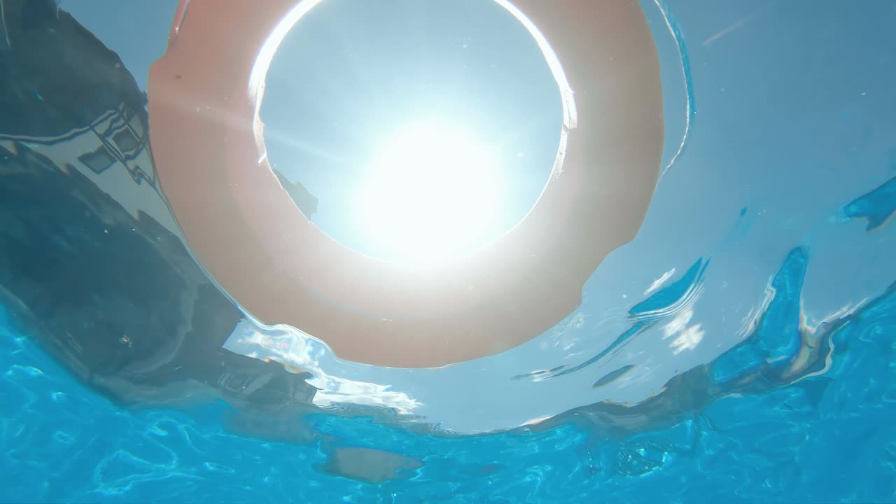 Safety equipment, Life buoy or rescue buoy floating on swimming pool to rescue people from drowning man, slow motion, underwater view