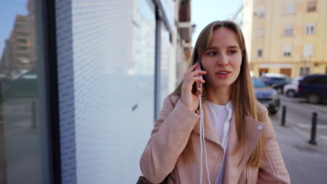 una mujer joven hablando por teléfono en una calle de la ciudad.