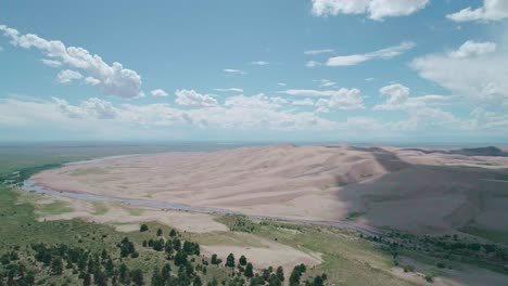 vista de drones de suelo de arena roja y un suelo de hierba separados por un río en colorado