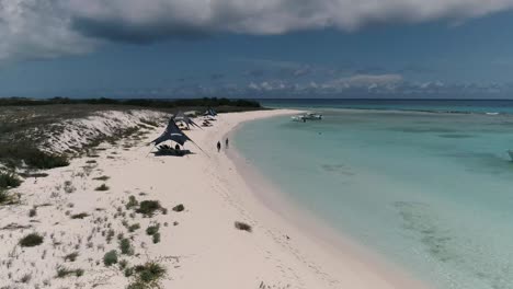 Vista-Aérea-De-La-Costa-De-La-Isla-De-Cayo-De-Agua-Con-Sombrillas-Y-Gente-Alegre-Día-De-Playa