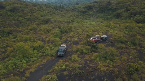 beautiful drone aerial rotating view of cars driving off-road during a camping trip to pacaya volcano in guatemala, central america