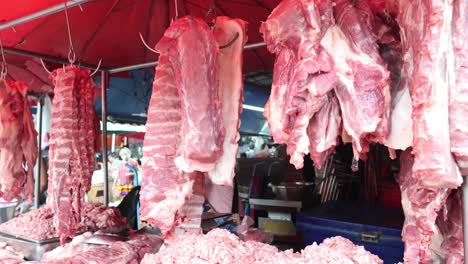 butcher arranging meat cuts at market stall