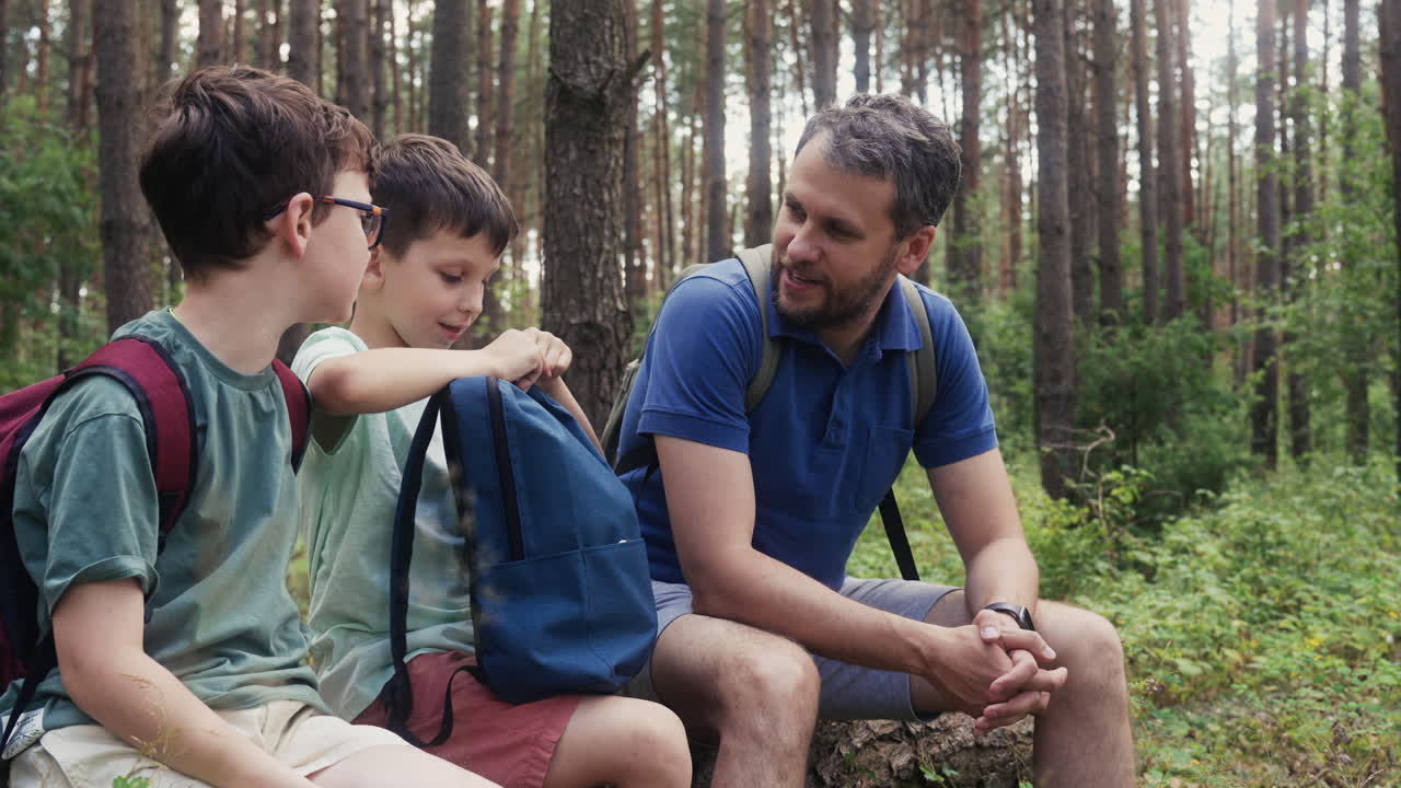 familia sentada en el tronco en el bosque