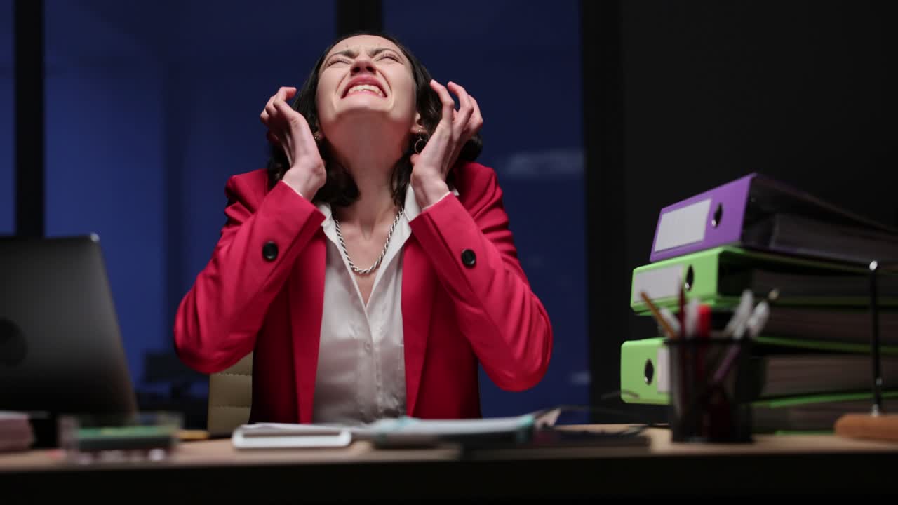 Woman experiences extreme stress and burnout while working late in the office