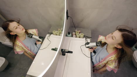 girl drying her hair in the bathroom