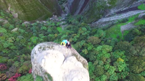 climbers ascend a sheer pinnacle spire in meteora greece