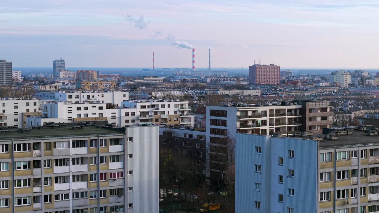 Densely populated residential neighbourhood of Mokotow district in Warsaw with coal power plant smoke stack at distant, Siekierki Power Station, Drone shot