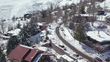 aerial view flying over snowy farellones ski resort village hotels, houses and streets in the andes mountains of santiago, chile