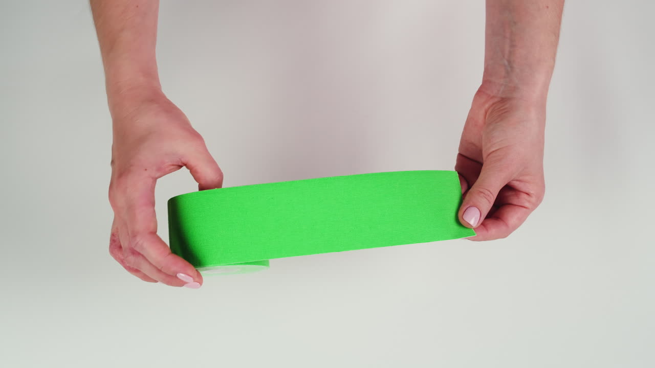 Kinesiology medical taping, doctor Physical therapist applying elastic surgical tape to patient body, treating injured knee young athlete.Post traumatic rehabilitation, sport physical therapy recovery