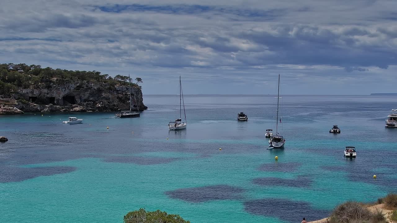 Boats sailing in the water near Mallorca, Spain during a cloudy day