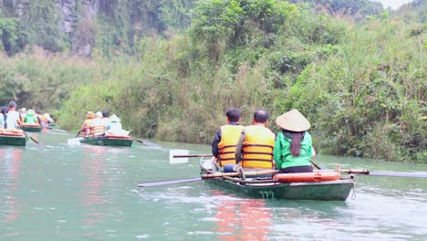 people rowing boats through lush river scenery