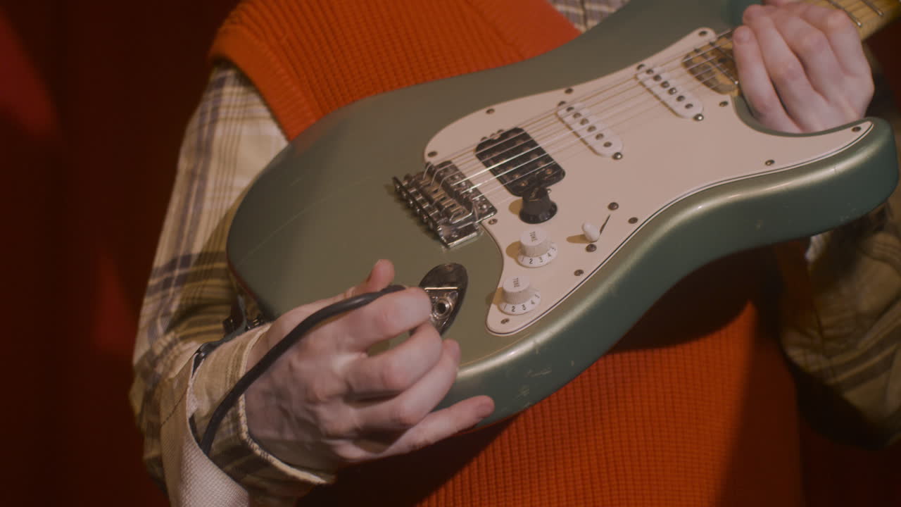 보라색 배경에 카메라 앞에서 포즈를 취한 귀걸이를 끼고 짧은 머리와 녹색 눈을 가진 고위 여성의 얼굴을 가까이서 볼 수 있습니다.