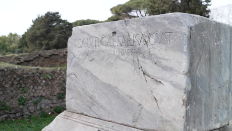 an ancient roman inscribed granite pillar at the seaport historic site of ostia antica.