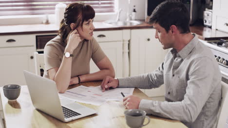 una pareja pasando por el papeleo juntos en casa