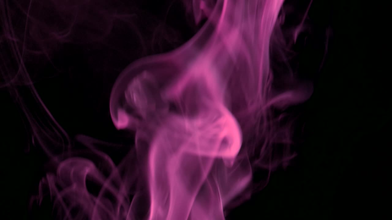 Nuvole di fumo rosa che salgono lentamente con eleganti volute verso l'alto. Fumo colorato che si diffonde dal basso verso l'alto. Primo piano, isolato su sfondo nero.