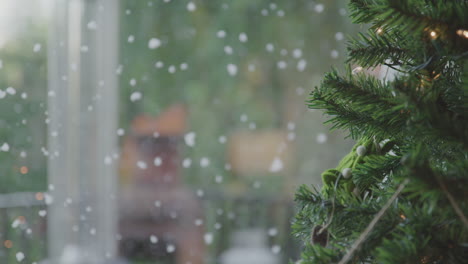 la nieve cae lentamente al aire libre a través de la ventana cerca del árbol de navidad