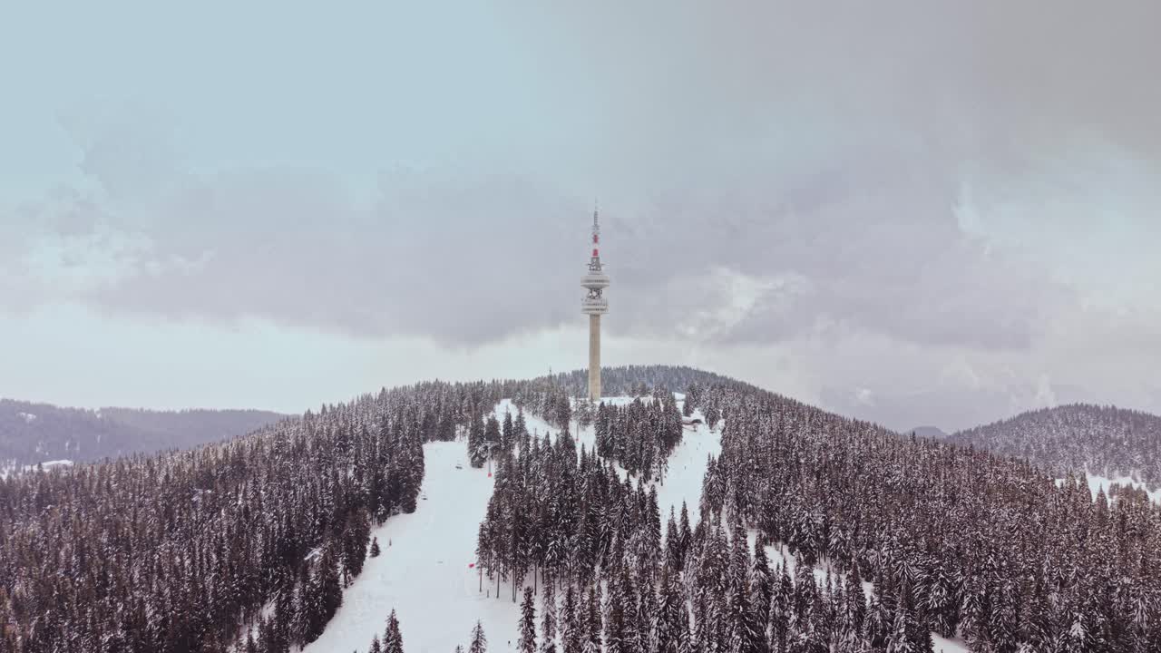 Schneebedeckte Berge in den Karpaten mit einem hohen Turm in Bulgarien