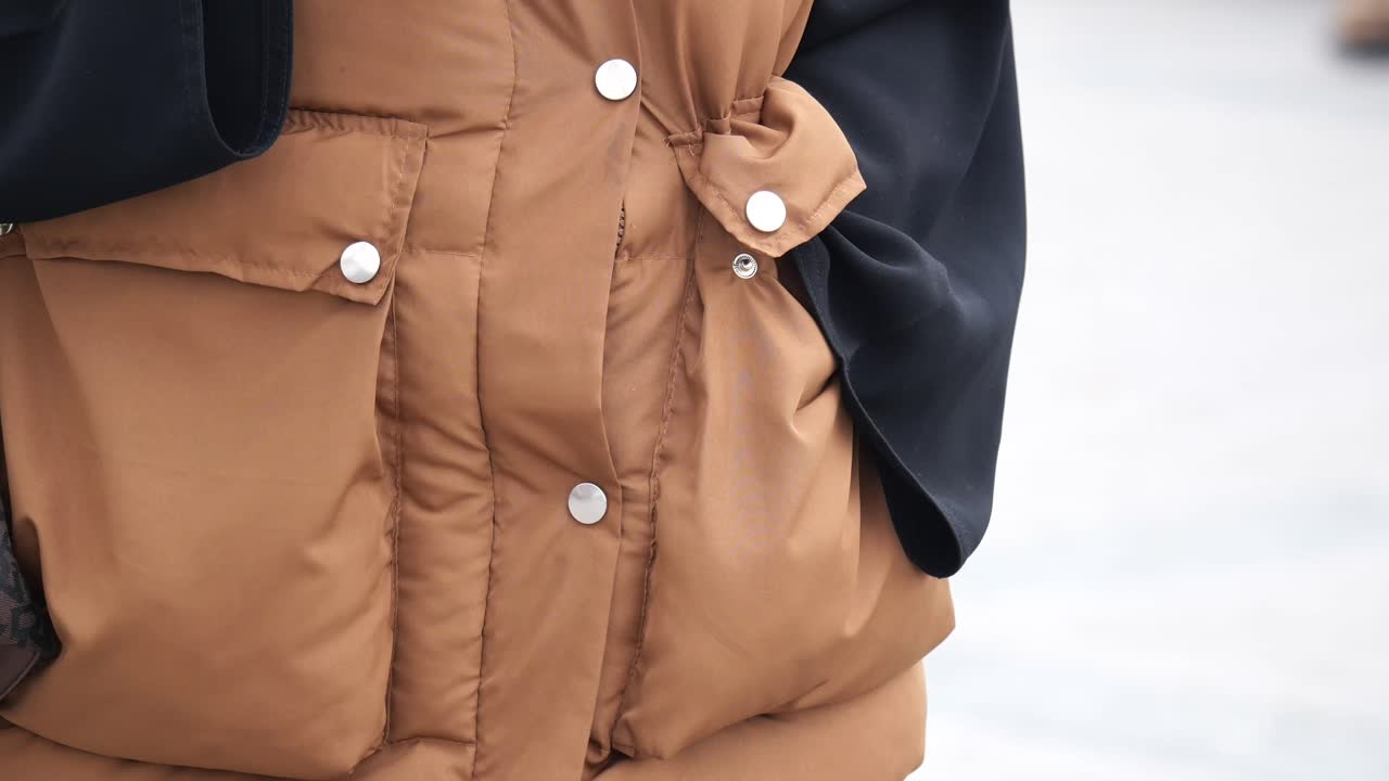 Close-up of a Brown Puffer Vest with Pockets and a Shoulder Bag