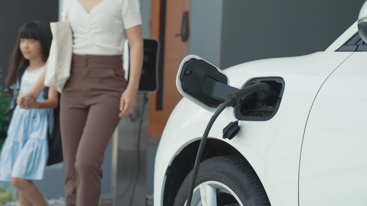 자동차와 충전소와 함께 어머니와 딸의 진보적인 라이프 스타일.