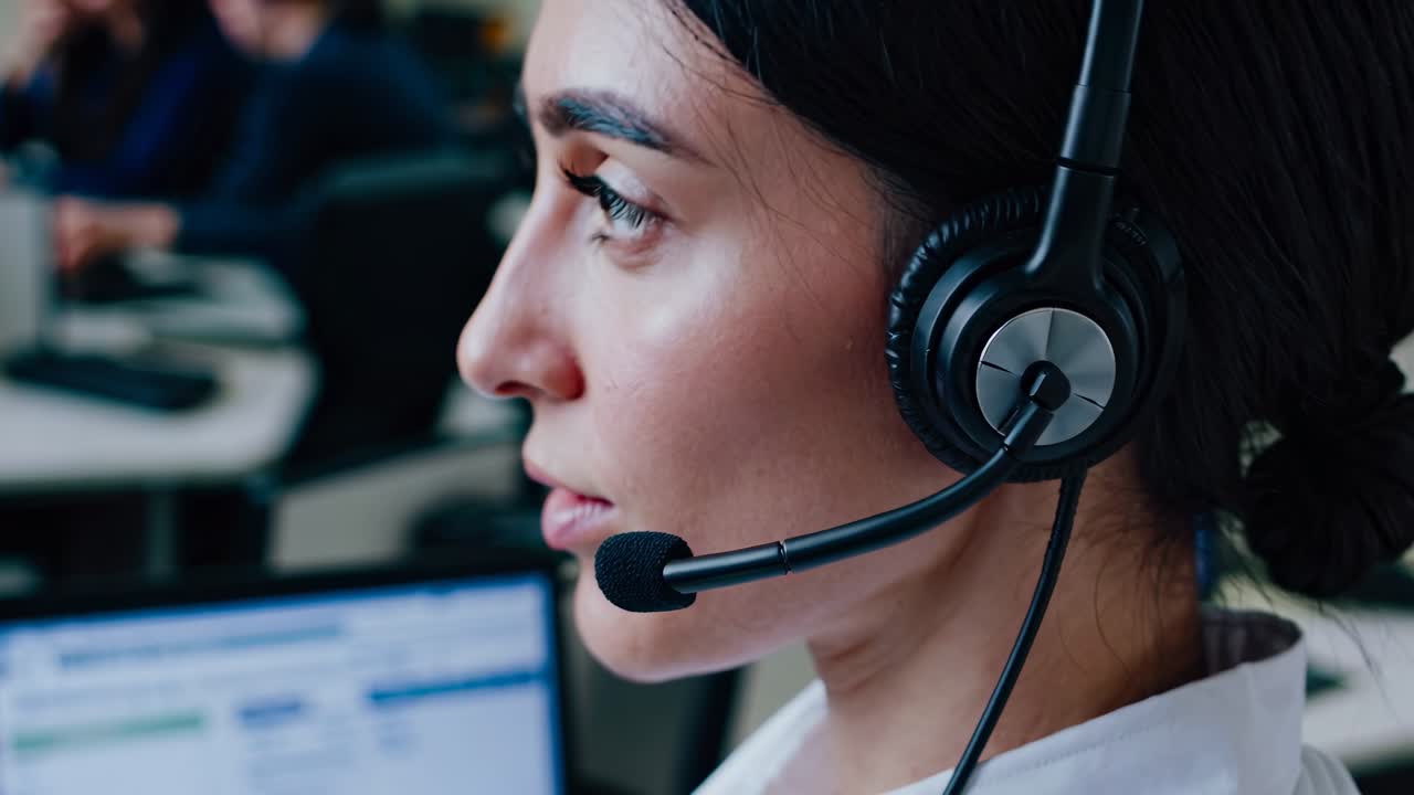 Close-up side view of a woman with a headset in a call center