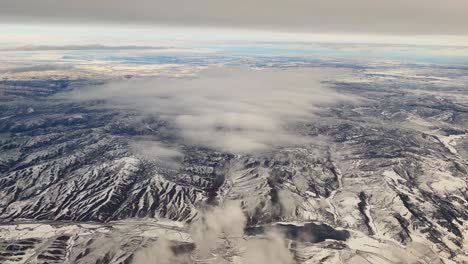 por encima de las nubes mirando hacia abajo en las montañas nevadas de utah