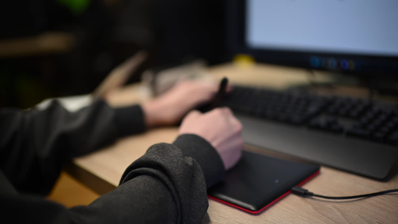 Persona che usa una tavoletta grafica collegata a un computer per lavoro di design digitale.