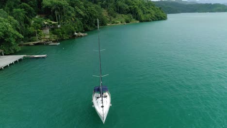 Toma-Aérea-De-Drones-En-órbita-De-Un-Velero-Amarrado-Cerca-Del-Muelle-De-Una-Maravillosa-Isla-Tropical