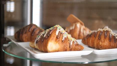 primer plano de deliciosos croissants de chocolate con salpicaduras en exhibición en una panadería