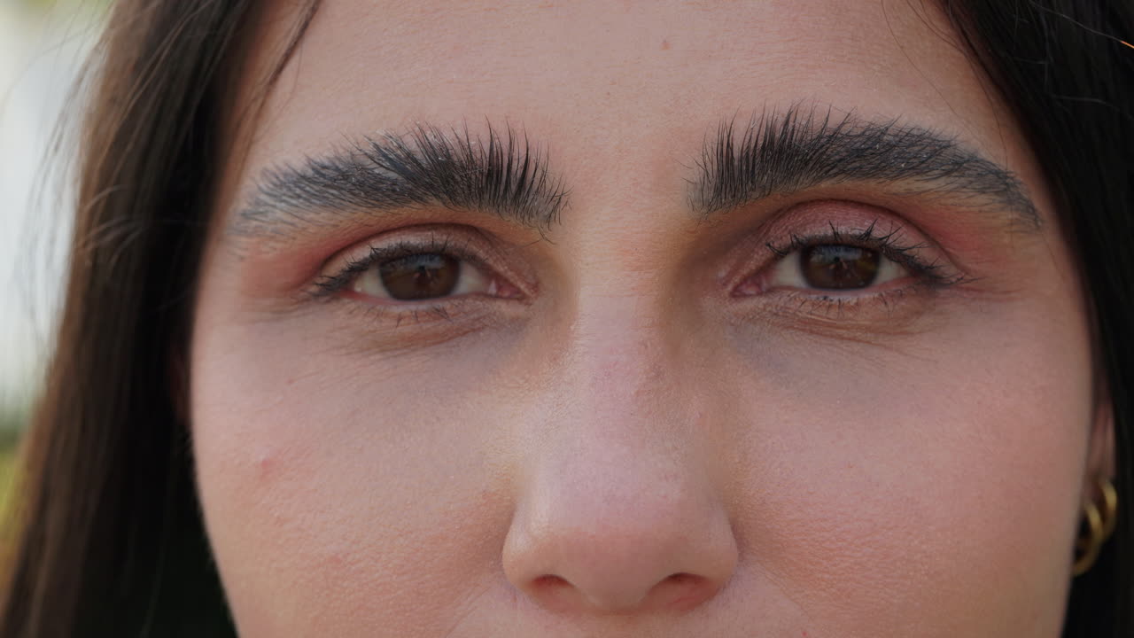 Close-up portrait of a woman's face with striking eyebrows