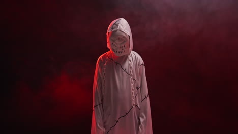 child dressed up in ghost zombie monster costume trick or treating at halloween scaring people against red smoke background 8