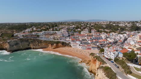 Orangefarbenes-Dach,-Weiße-Wand,-Villen,-Häuser-Und-Türkisfarbenes-Wasser,-Das-Am-Sandstrand,-Carvoeiro-Dorf,-Algarve,-Abstürzt