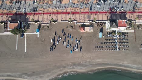 aerial drone look down of fuengirola coast beach, zoom sailboats at shore