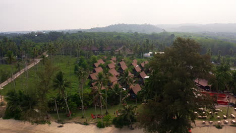 Seaside-bungalow-resort-below-palm-trees-on-tropical-Koh-Kood-beach