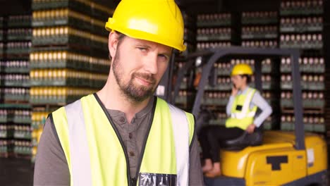 Male-supervisor-maintaining-record-on-clipboard-in-warehouse