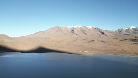 laguna route and volcanic peaks in bolivia, blue water lagoon in natural reserve valley, idyllic surreal travel and tourism destination, latin america, aerial view