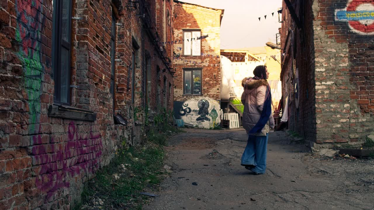 Woman walking down a graffiti-covered alleyway