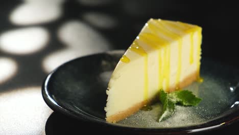 a piece of lemon sweet dessert on a plate on a black background.