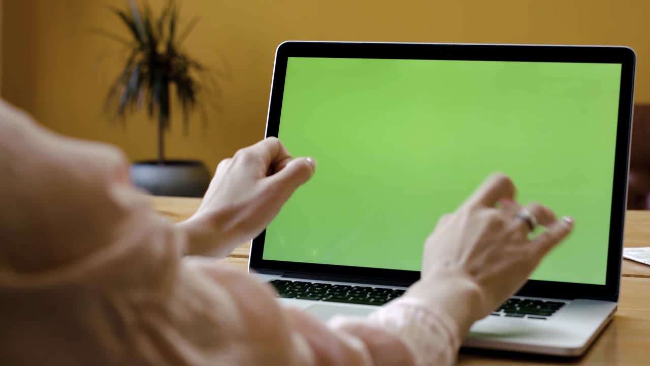 mujer trabajando en una computadora portátil con una pantalla verde