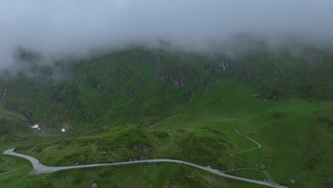 Vehicle-drives-through-green-landscape,-sky-covered-by-thick-white-fog