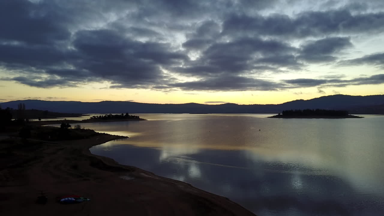 puesta de sol sobre las tranquilas olas y el paisaje de jindabyne, australia -ascenso aéreo