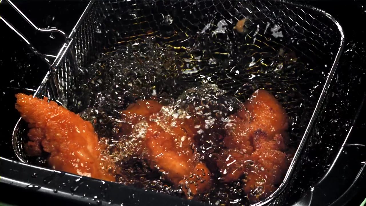 泡立つ熱い油で揚げられるクリスピーチキン