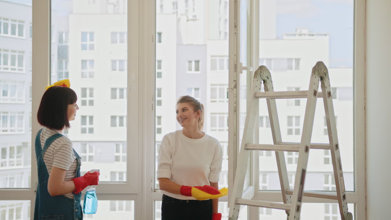 dos mujeres limpiando ventanas