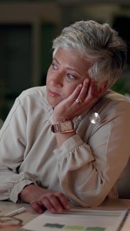 a woman in a business setting, looking concerned and thinking about work.