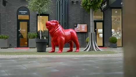 red bulldog statue in city setting