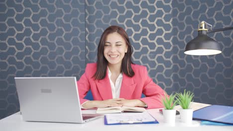 Young-business-woman-happily-speaking-to-camera.