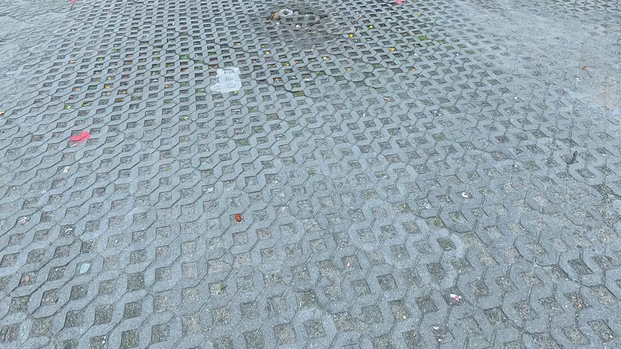 A sequence showing a textured brick floor in Koh Samui, Thailand, with subtle lighting changes and scattered debris