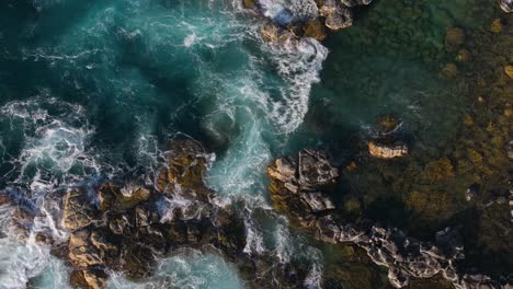 aerial view of ocean waves crashing on rocky coast
