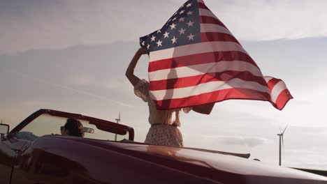 video de una pareja en un coche con una bandera estadounidense