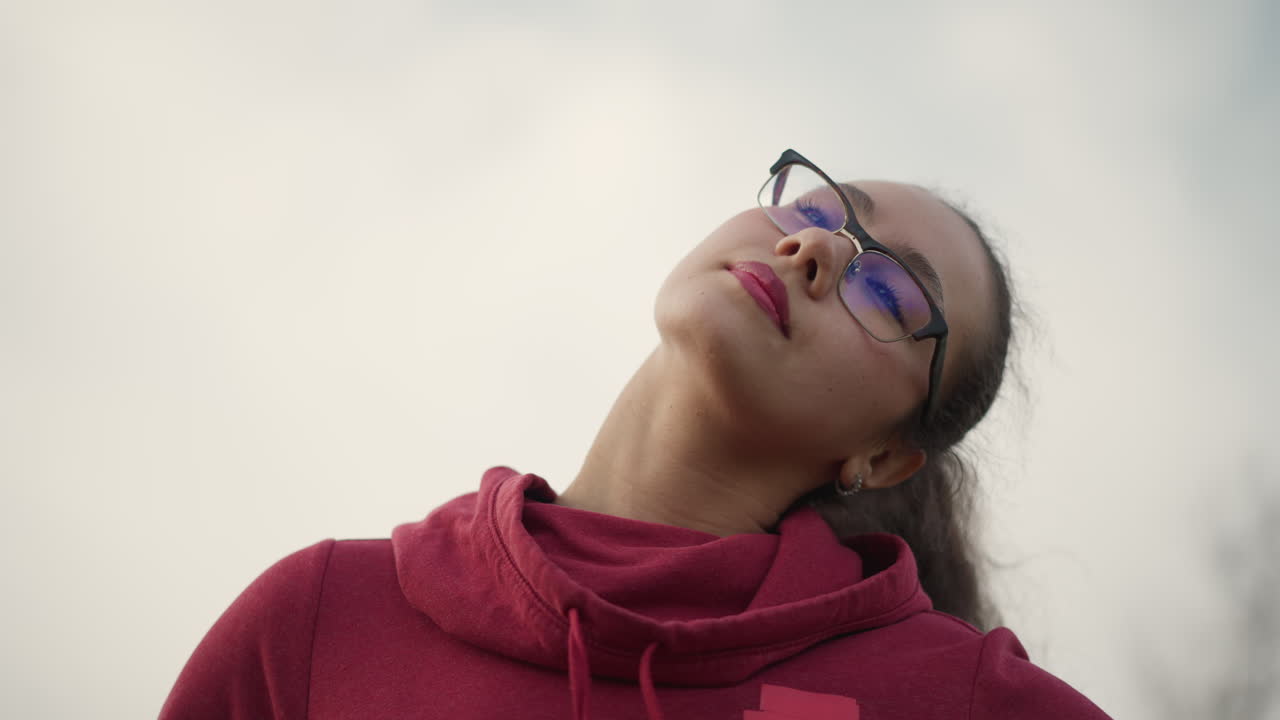Young Woman Tilts Head Gracefully, Profile View Of Woman With Ponytail And Tranquil Environment, Young Woman In Profile Performing Gentle Stretch With Calm Surroundings And Focused Breath