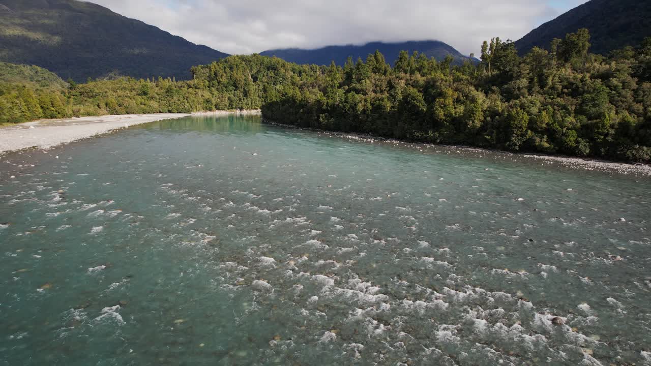 Hokitika River Flowing Through Dense Green Forest On West Coast Of New Zealand's South Island. drone sideways shot
